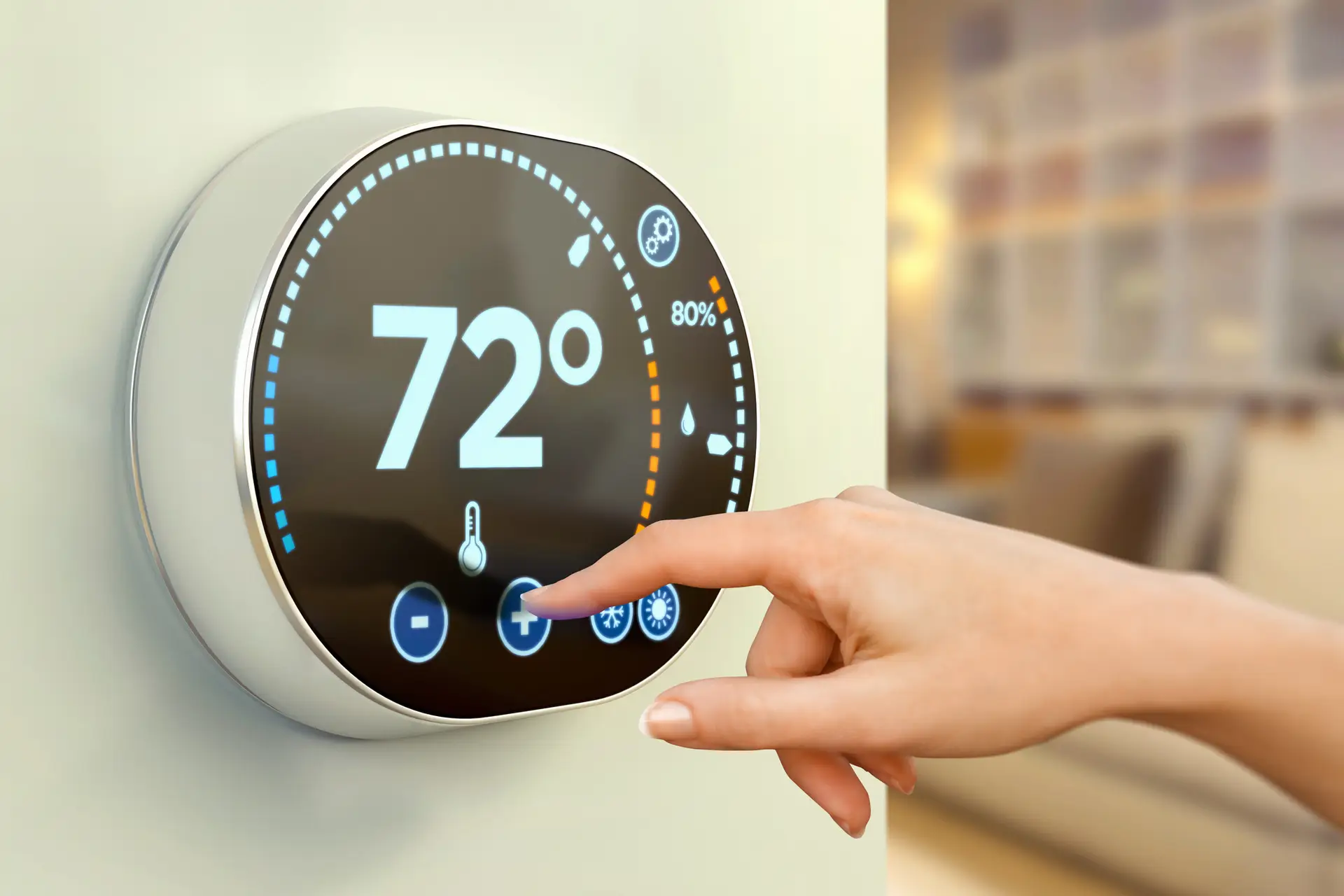 woman hand controlling house temperature with a multimedia touch screen display